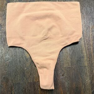 SKIMS Women's Seamless Sculpt Mid Waist Thong in the color "Sand” size s/m
